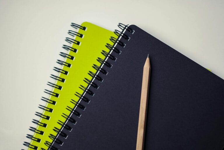 brown pencil on black and green book