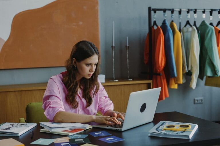 woman in pink long sleeve shirt using macbook