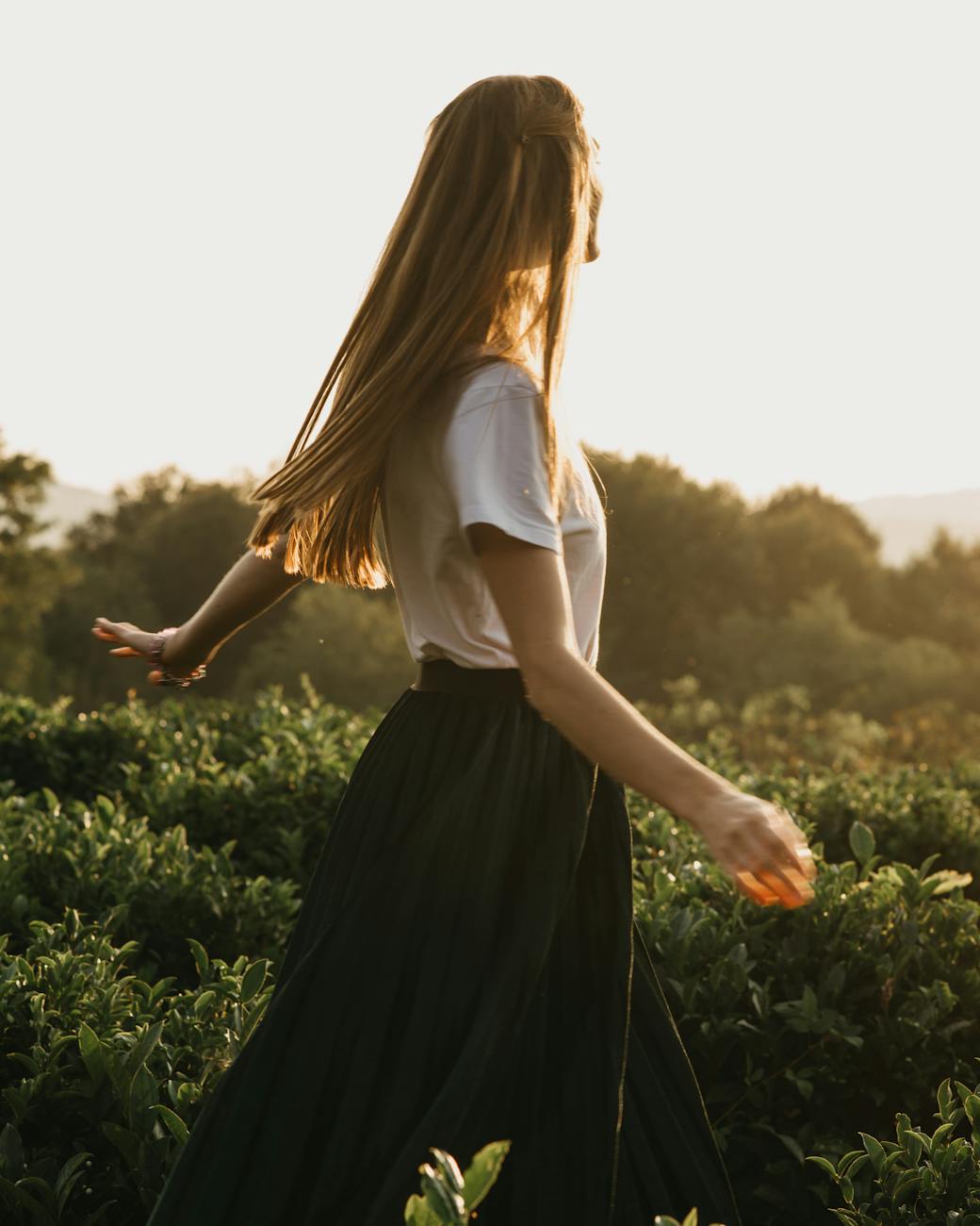 unrecognizable woman walking among plants