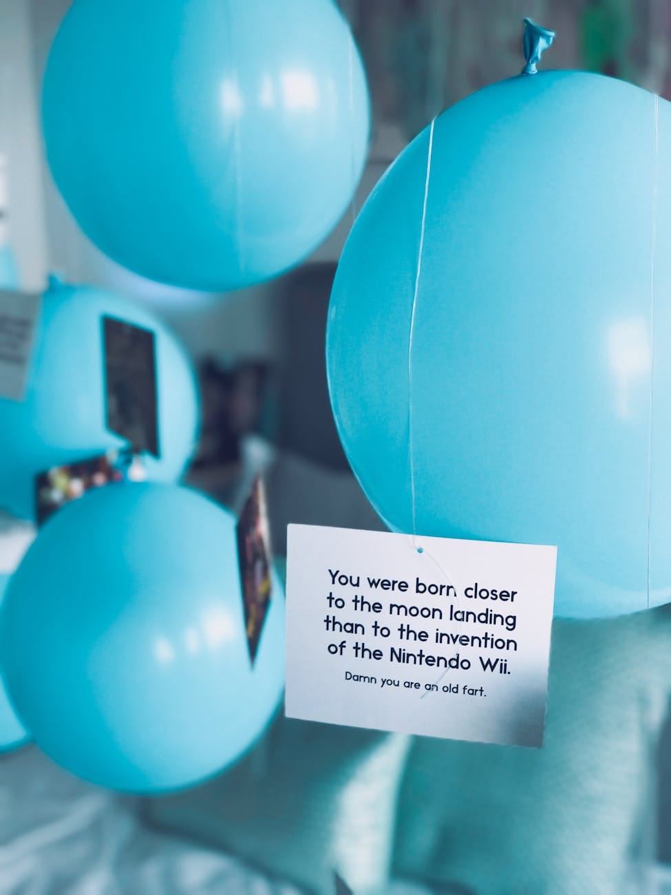 close up photo of baby blue balloons with letter card