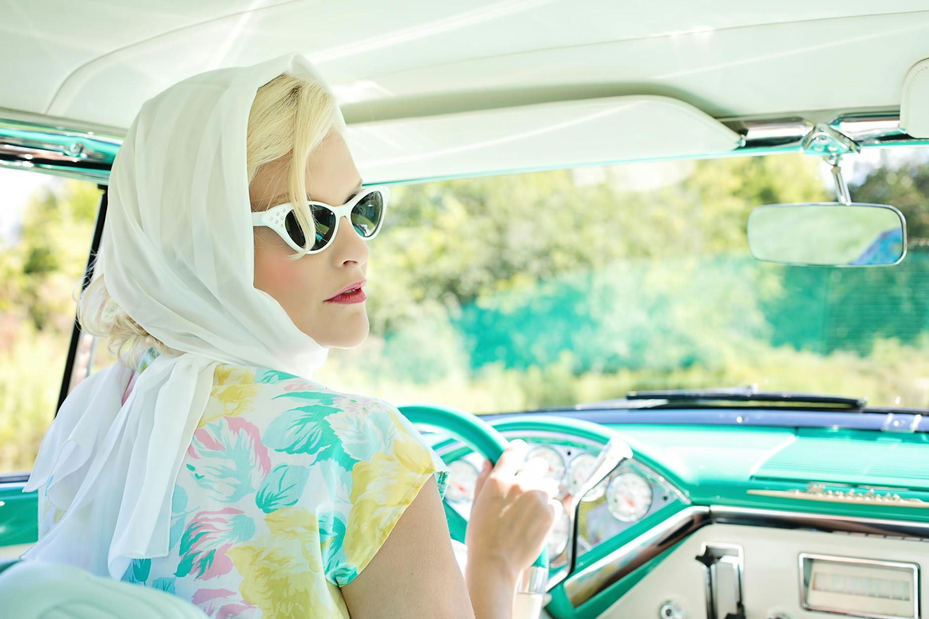 woman driving vintage car on road during daytime