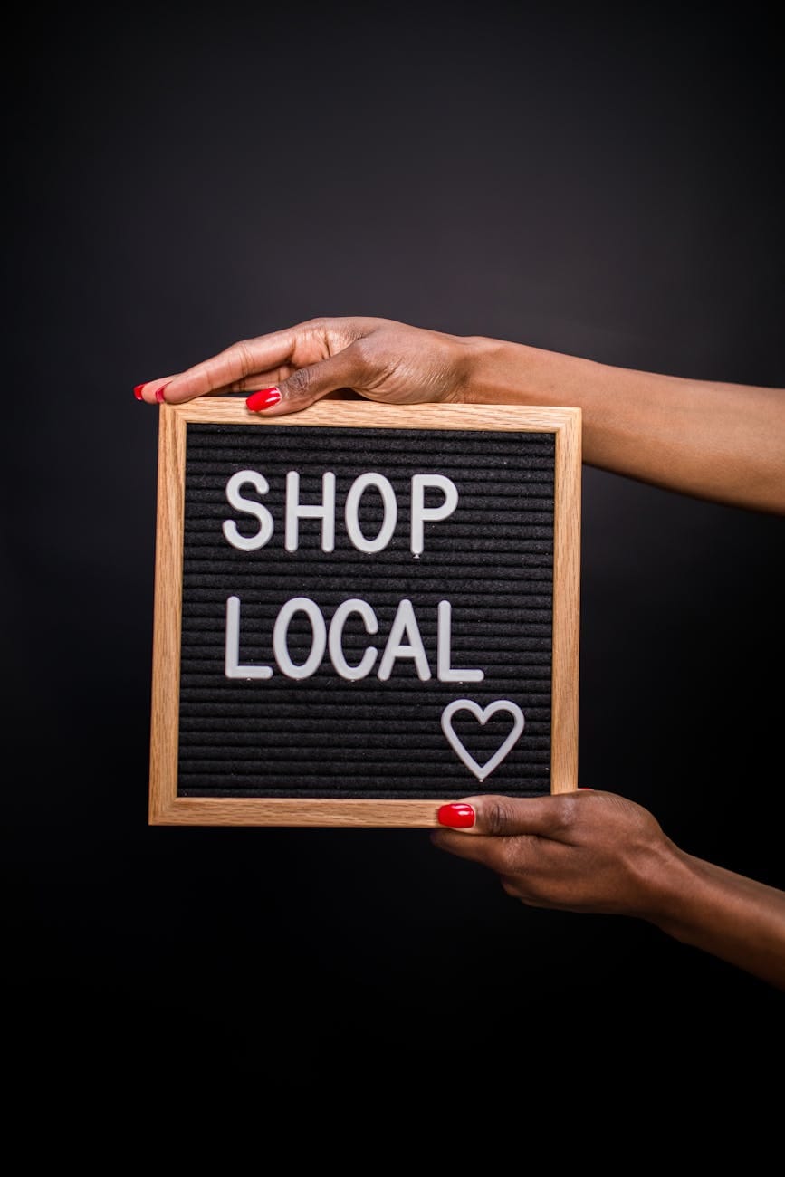 a person holding a letter board with shop local text