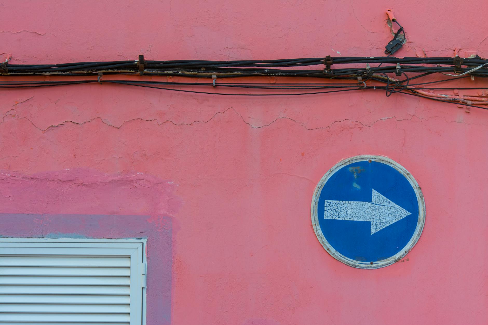 road sign and wires on building wall