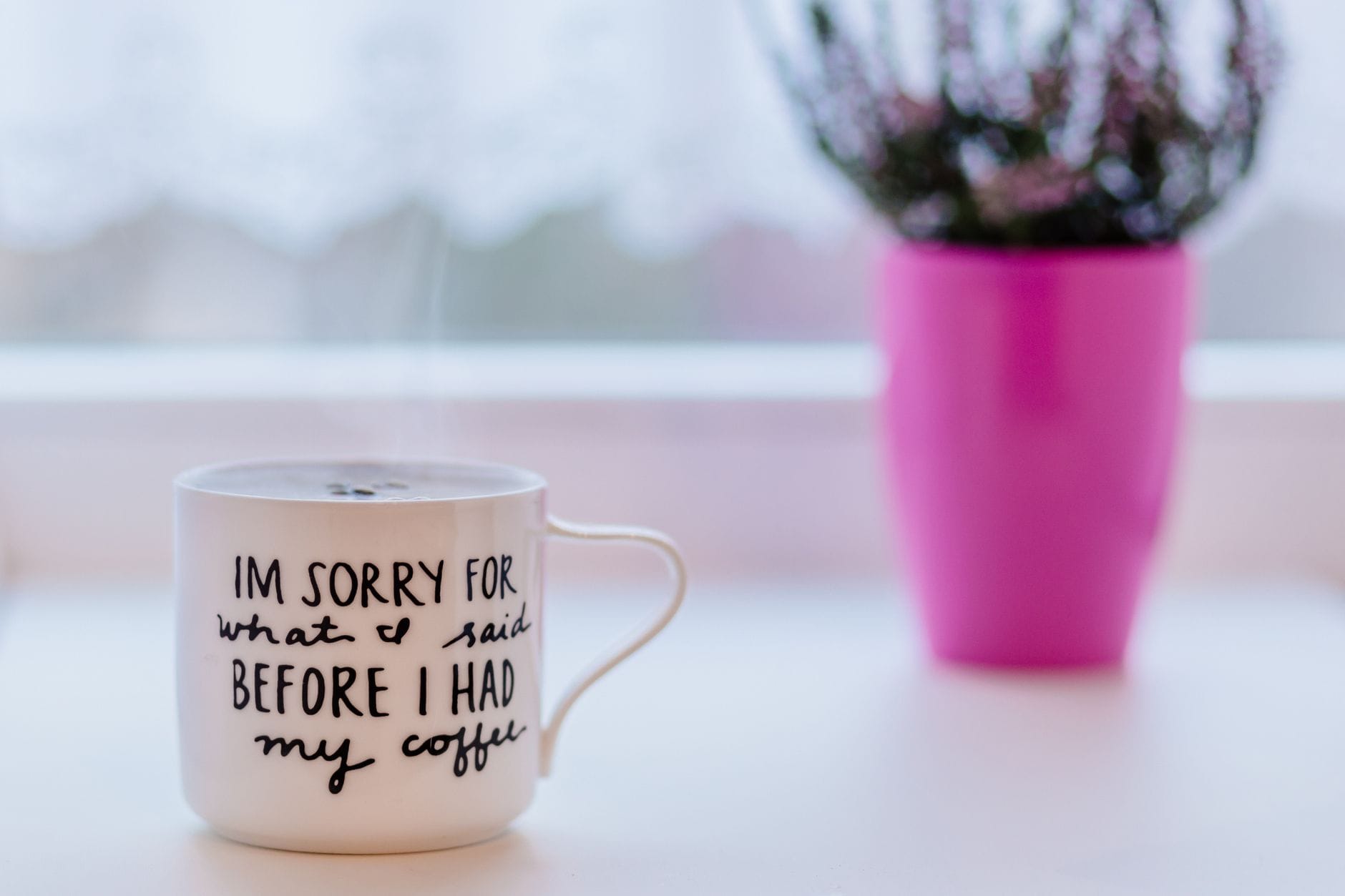 focus photo of a white ceramic mug on white table