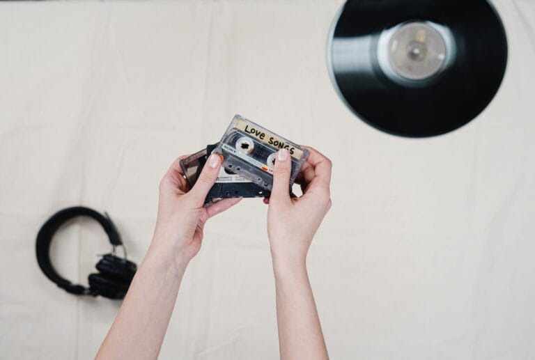 person holding a love song cassette tape
