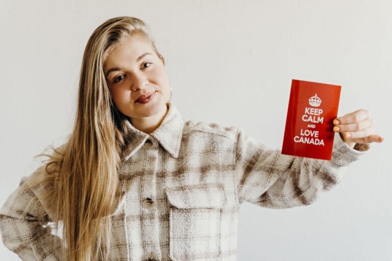 a woman holding a red card with message while smiling at the camera