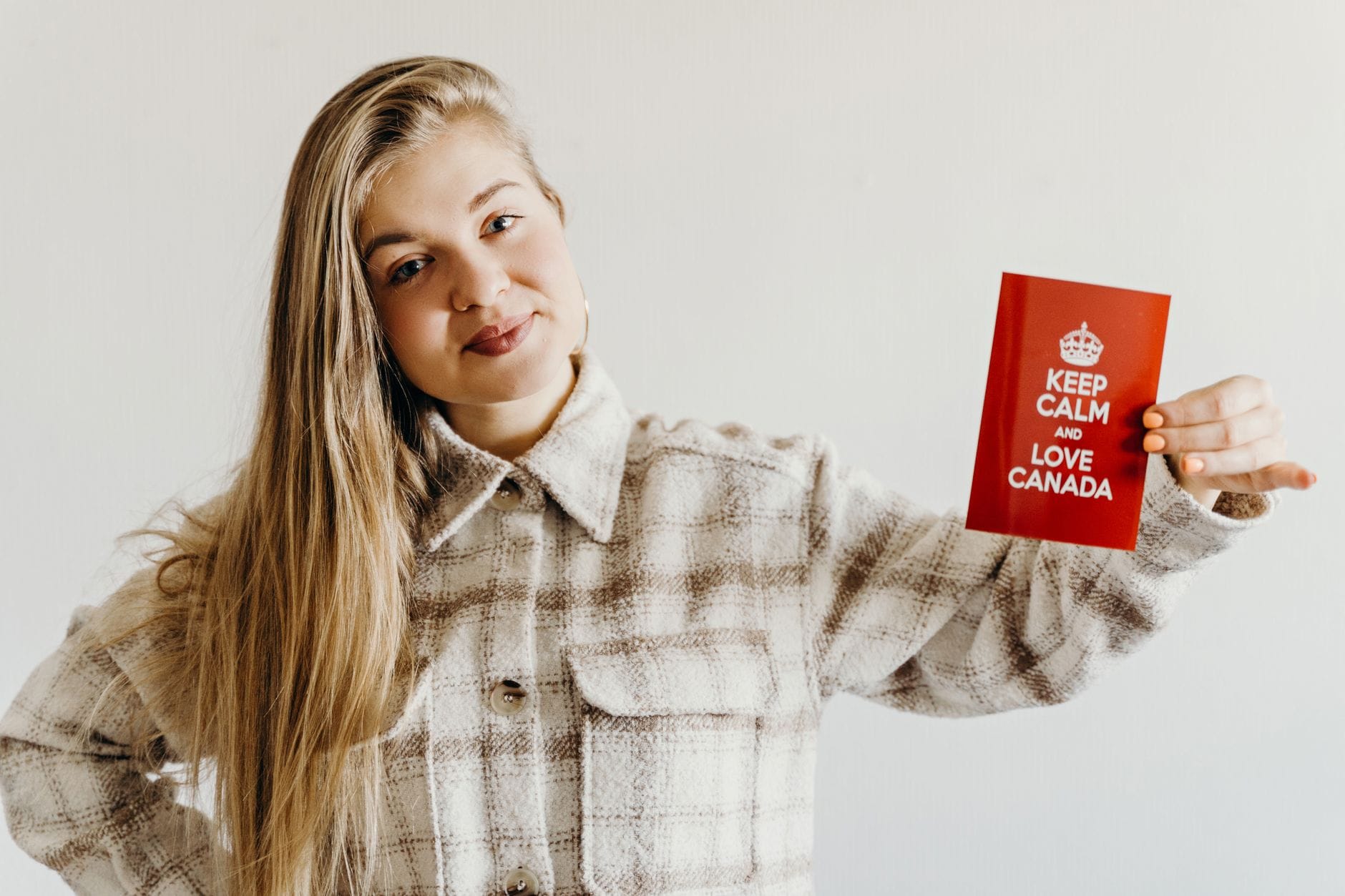 a woman holding a red card with message while smiling at the camera