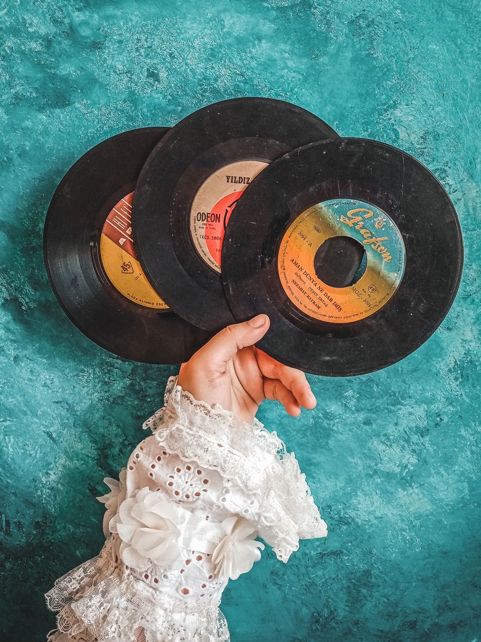 person holding three lp records
